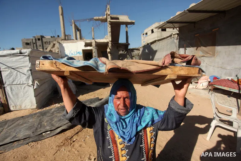 A Palestinian woman walks near the rubble of buildings that were destroyed during 50-day Israeli on Gaza Strip in the summer of 2014, east of Khan Younis in the southern Gaza Strip on June 22, 2015. A widely anticipated...