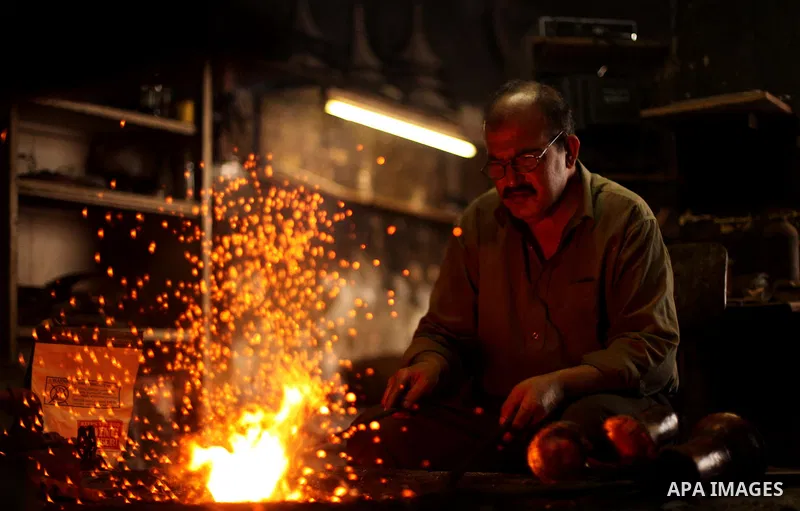 A Palestinian copper, Mohammed Abdo 53, works at his workshop, in Gaza city, on June 24, 2015. Abdo inherited copper profession from his father for nearly 40 years. Make replicas Crescent attached to mosques. He is the o...