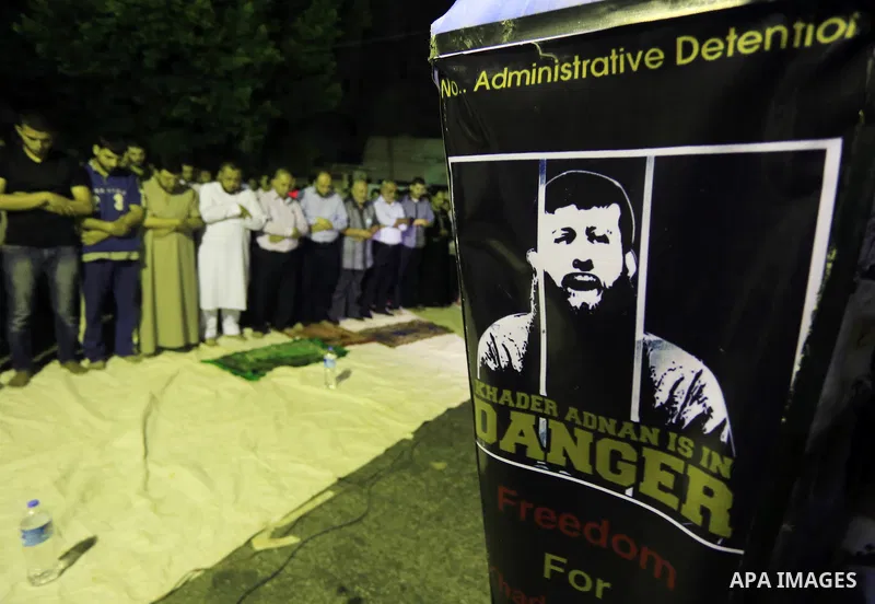 Palestinian worshipers perform 'taraweeh', nightly prayer of the month of Ramadan, in a rally to support Palestinian Khader Adnan, a senior member of the Islamic Jihad who was jailed in Israel without a trial, in outside...