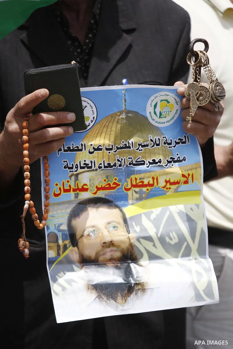 Palestinians hold placard during a protest in support of Palestinian Khader Adnan, a senior member of the Islamic Jihad who was jailed in Israel without a trial, in the West Bank city of Ramallah on June 25, 2015. Photo...