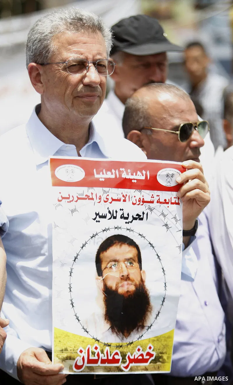 Palestinians hold placard during a protest in support of Palestinian Khader Adnan, a senior member of the Islamic Jihad who was jailed in Israel without a trial, in the West Bank city of Ramallah on June 25, 2015. Photo...