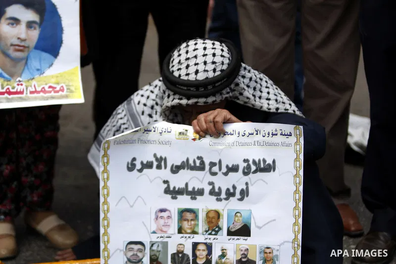 Palestinians hold placard during a protest in support of Palestinian Khader Adnan, a senior member of the Islamic Jihad who was jailed in Israel without a trial, in the West Bank city of Ramallah on June 25, 2015. Photo...