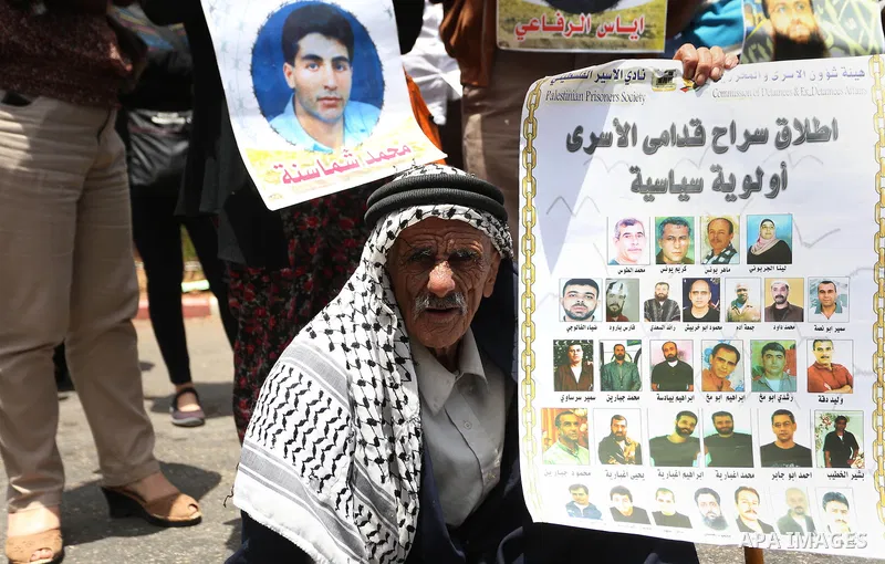Palestinians hold placard during a protest in support of Palestinian Khader Adnan, a senior member of the Islamic Jihad who was jailed in Israel without a trial, in the West Bank city of Ramallah on June 25, 2015. Photo...
