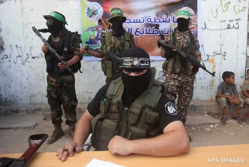 Members of Izzedine al-Qassam brigades, loyal to Hamas movement stand guard during register for the summer camps in Dair Al Balah in the center of Gaza strip on June 25, 2015. Photo by Ashraf Amra