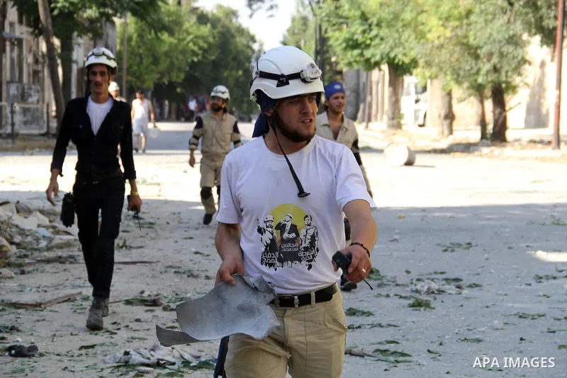 Syrian rescue workers walk in an a street after a reported bomb barrel attack by Syrian government forces in Jub al-Qubbah neighborhood in the northern Syrian city of Aleppo, June 26, 2015. Photo by Ameer al-Halbi