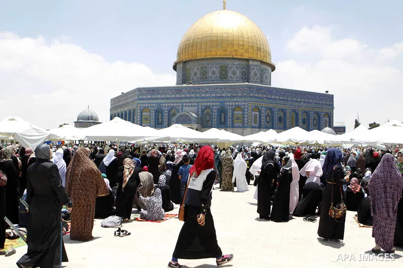 Palestinian Muslim worshipers pray outside the Dome of the Rock at the Al-Aqsa Mosque compound in Jerusalem during the second Friday prayer of the holy month of Ramadan, on June 26, 2015. Photo by Saeb Awad
