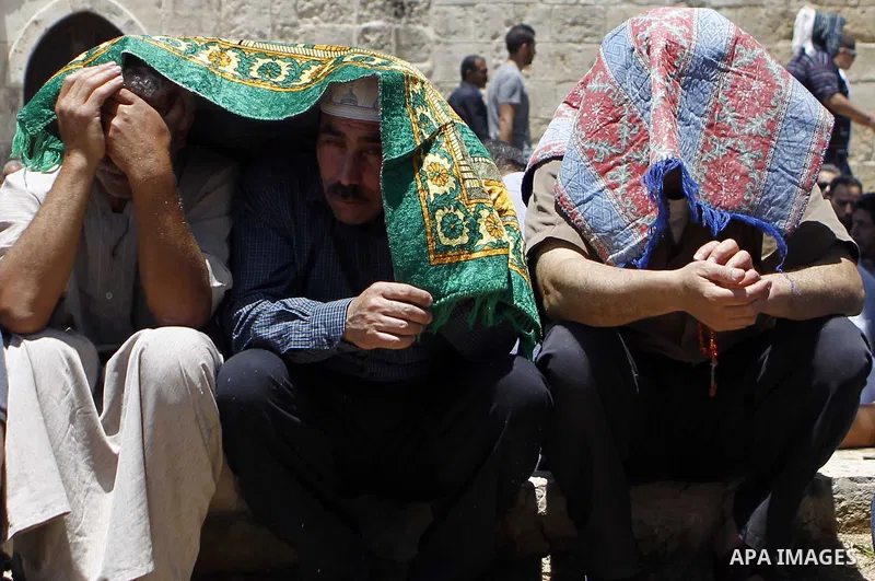 Palestinian Muslim worshipers pray outside the Dome of the Rock at the Al-Aqsa Mosque compound in Jerusalem during the second Friday prayer of the holy month of Ramadan, on June 26, 2015. Photo by Saeb Awad