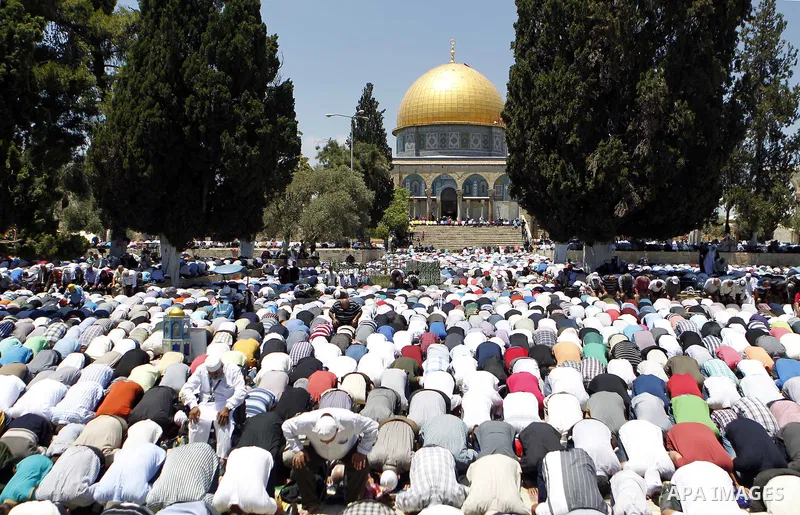 Palestinian Muslim worshipers pray outside the Dome of the Rock at the Al-Aqsa Mosque compound in Jerusalem during the second Friday prayer of the holy month of Ramadan, on June 26, 2015. Photo by Saeb Awad
