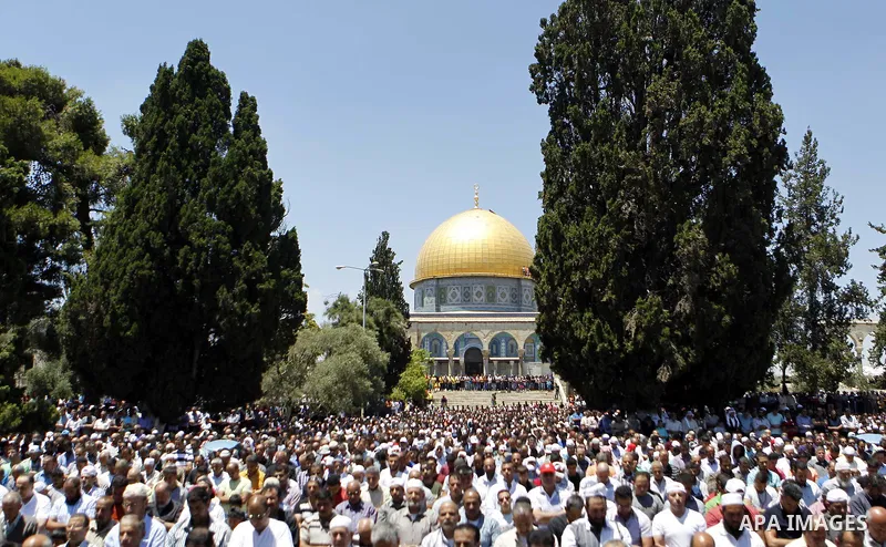 Palestinian Muslim worshipers pray outside the Dome of the Rock at the Al-Aqsa Mosque compound in Jerusalem during the second Friday prayer of the holy month of Ramadan, on June 26, 2015. Photo by Saeb Awad