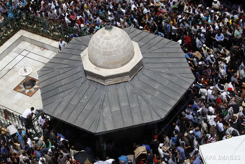 Palestinian Muslim worshipers pray outside the Dome of the Rock at the Al-Aqsa Mosque compound in Jerusalem during the second Friday prayer of the holy month of Ramadan, on June 26, 2015. Photo by Saeb Awad
