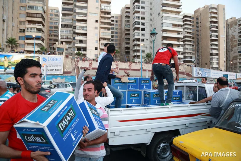 Egyptians carry water bottles as others wait to break their daytime fast, during the Muslim holy month of Ramadan, in Egypt s Mediterranean city of Alexandria, Friday, June 26, 2015. Alexandria is seeking to enter the Gu...