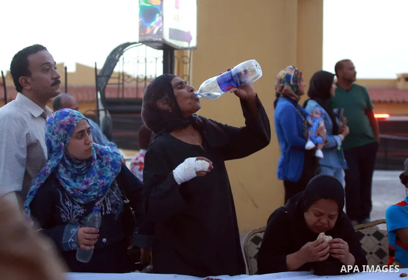 An Egyptian woman breaks her daytime fast next to an Iftar table, during the Muslim holy month of Ramadan, in Egypt s Mediterranean city of Alexandria, Friday, June 26, 2015. Alexandria is seeking to enter the Guinness B...
