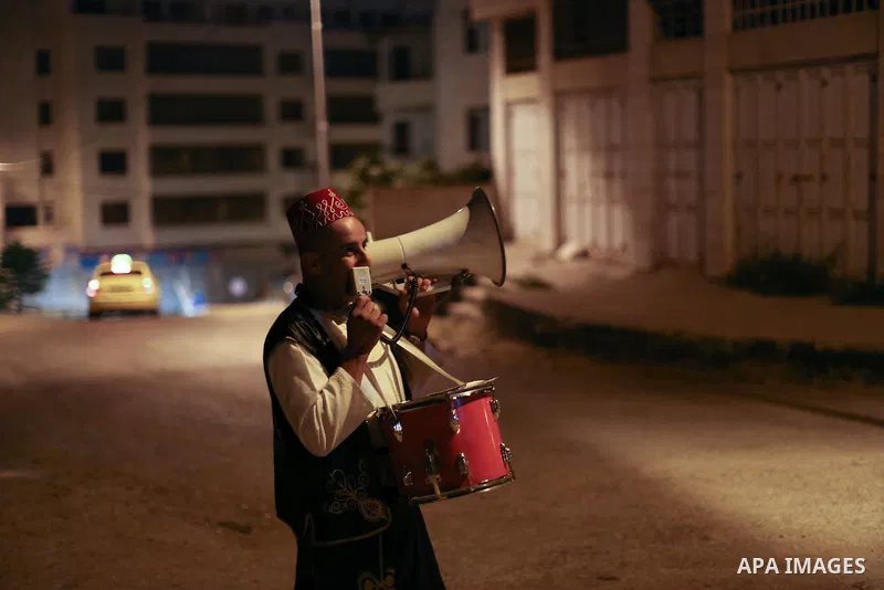 A Palestinian dawn awakener or Al Musaharati in Arabic, beats on his drum to wake up Muslims for a meal before sunrise, in the West Bank city of Nablus on July 27, 2015. Al-Musaharati is an old profession on its way to e...