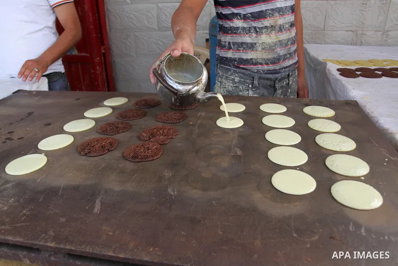 A Palestinian man prepares traditional pancakes known as ''Qatayef'' in a street market on the holy month of Ramadan, in Rafah in the southern Gaza Strip on June 27, 2015. During Ramadan, Muslim believers abstain from ea...