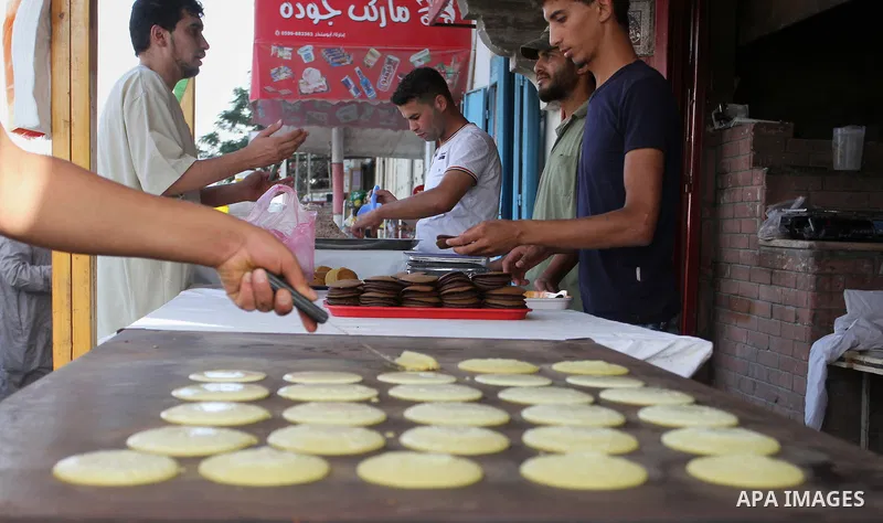 A Palestinian man prepares traditional pancakes known as ''Qatayef'' in a street market on the holy month of Ramadan, in Rafah in the southern Gaza Strip on June 27, 2015. During Ramadan, Muslim believers abstain from ea...