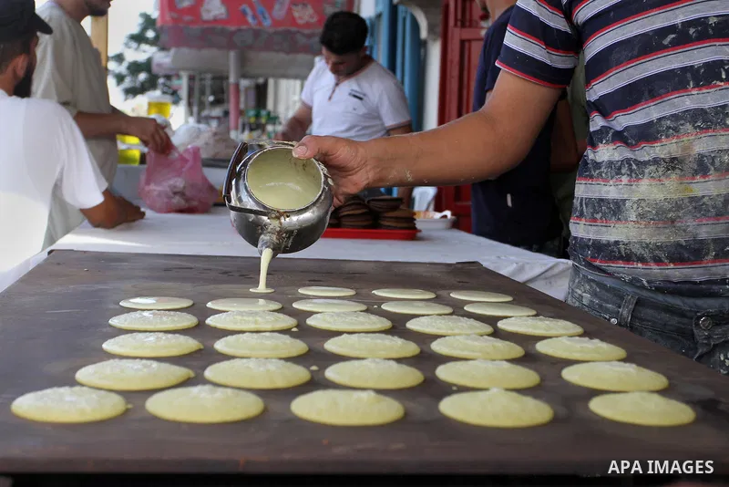 A Palestinian man prepares traditional pancakes known as ''Qatayef'' in a street market on the holy month of Ramadan, in Rafah in the southern Gaza Strip on June 27, 2015. During Ramadan, Muslim believers abstain from ea...