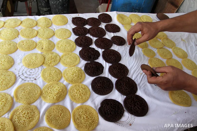 A Palestinian man prepares traditional pancakes known as ''Qatayef'' in a street market on the holy month of Ramadan, in Rafah in the southern Gaza Strip on June 27, 2015. During Ramadan, Muslim believers abstain from ea...