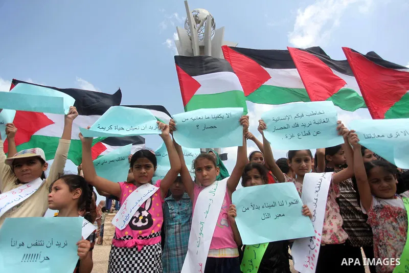 Palestinians children hold placards and wave their national flag during a rally to show support for activists aboard a flotilla of boats who are soon to set sail for Gaza in a fresh bid to break Israel's blockade of the...