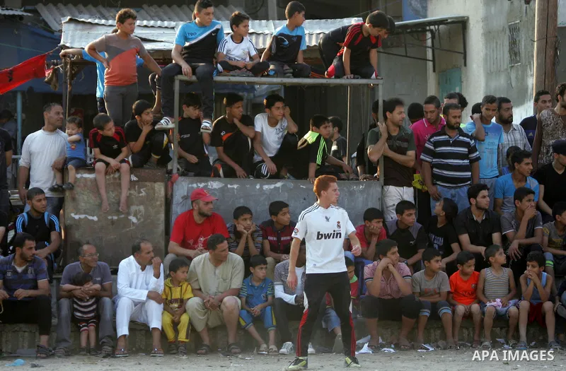 Palestinian youths play football match, at a refugee camp in Rafah, in the southern Gaza Strip, during the Muslim holy month of Ramadan on June 28, 2015. Muslims around the world abstain from food, drink and sexual inter...