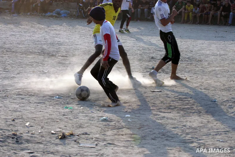 Palestinian youths play football match, at a refugee camp in Rafah, in the southern Gaza Strip, during the Muslim holy month of Ramadan on June 28, 2015. Muslims around the world abstain from food, drink and sexual inter...