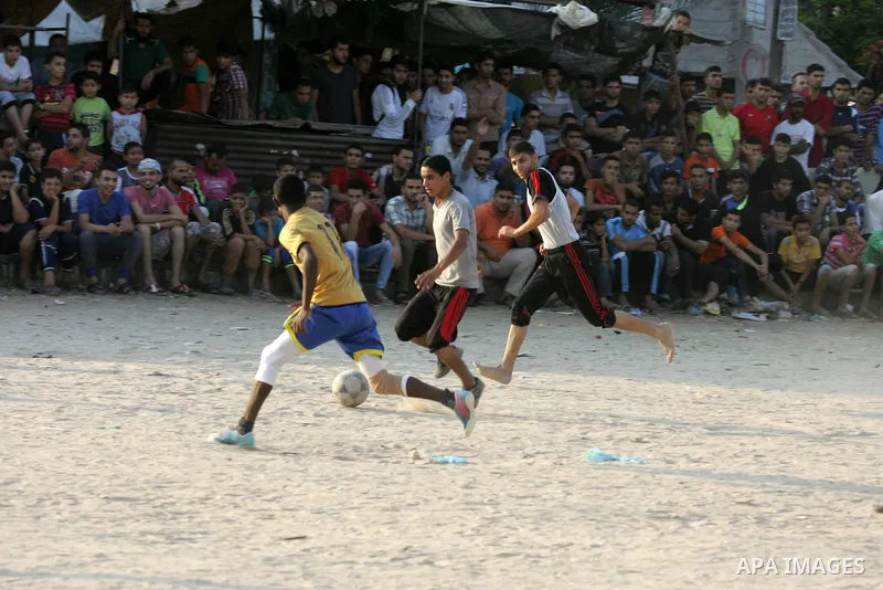 Palestinian youths play football match, at a refugee camp in Rafah, in the southern Gaza Strip, during the Muslim holy month of Ramadan on June 28, 2015. Muslims around the world abstain from food, drink and sexual inter...
