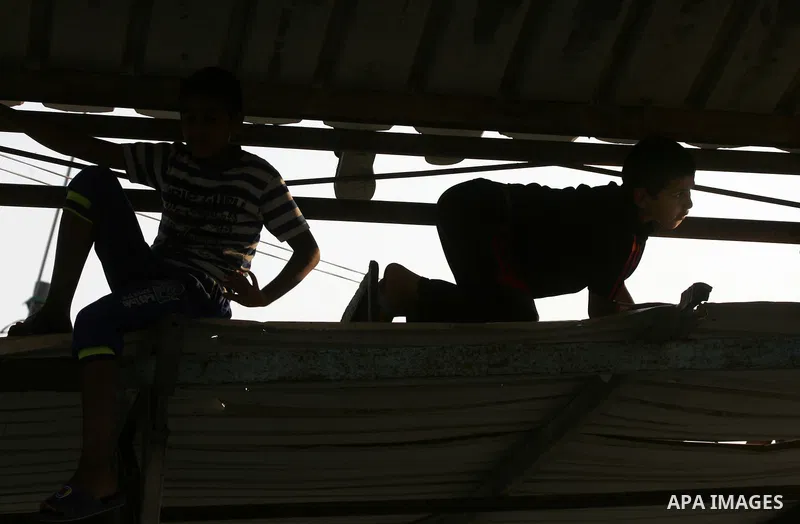 Palestinian youths watch football match, at a refugee camp in Rafah, in the southern Gaza Strip, during the Muslim holy month of Ramadan on June 28, 2015. Muslims around the world abstain from food, drink and sexual inte...