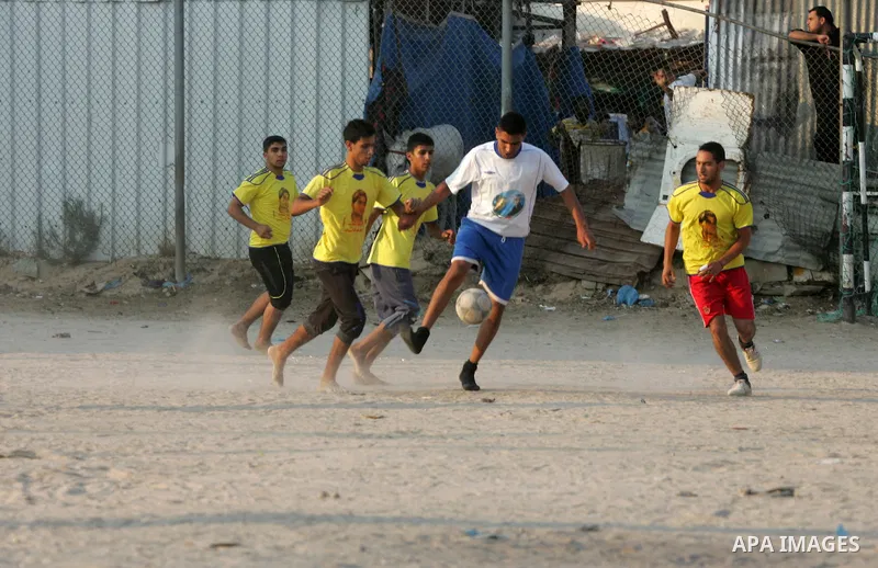 Palestinian youths play football match, at a refugee camp in Rafah, in the southern Gaza Strip, during the Muslim holy month of Ramadan on June 28, 2015. Muslims around the world abstain from food, drink and sexual inter...
