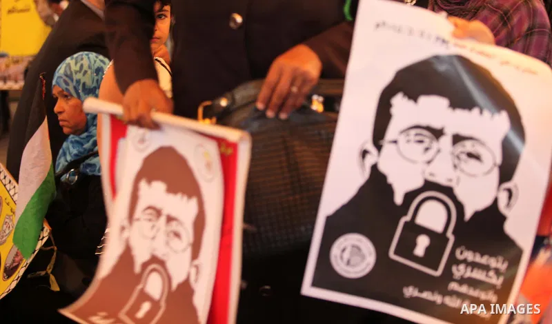 Palestinians take part in a protest demanding release the prisoners in Israeli jails, in front of Red cross office, in Gaza city, on June 29, 2015. Photo by Ashraf Amra