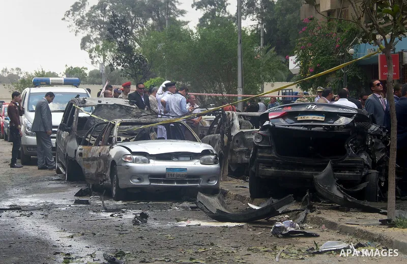 Members of the Egyptian security forces stand guard as people gather at the site of a bomb that targeted the convoy of the Egyptian state prosecutor, Hisham Barakat, in the capital Cairo on June 29, 2015. Egypt's state p...