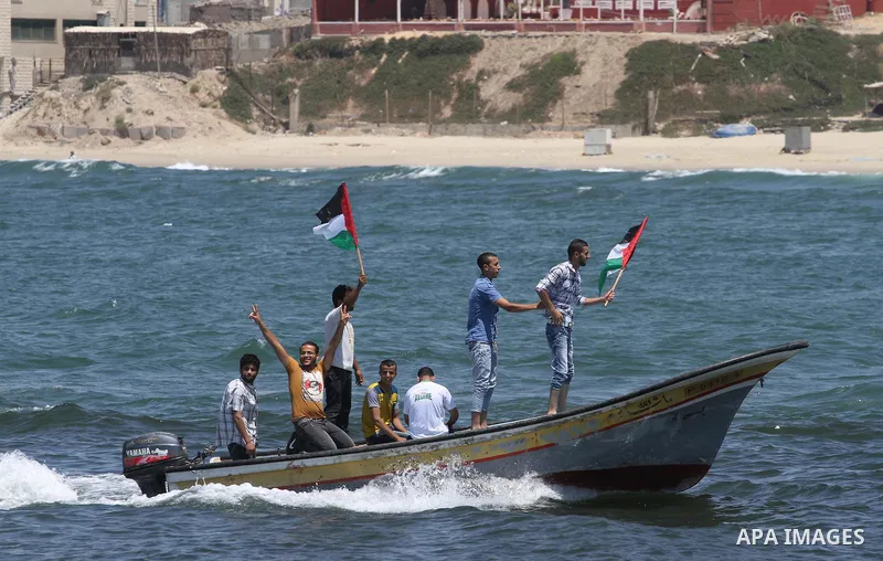 Palestinians riding boats hold Palestinian flags during a protest against the Israeli blocking of a boat of foreign activists from reaching Gaza, at the Seaport of Gaza City June 29, 2015. Israel said on Monday it had bl...