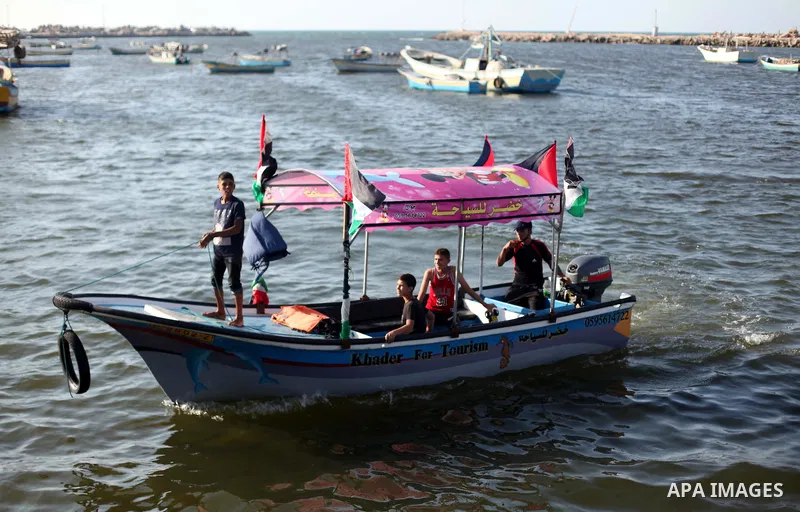 Palestinians riding boats hold Palestinian flags during a protest against the Israeli blocking of a boat of foreign activists from reaching Gaza, at the Seaport of Gaza City June 29, 2015. Israel said on Monday it had bl...