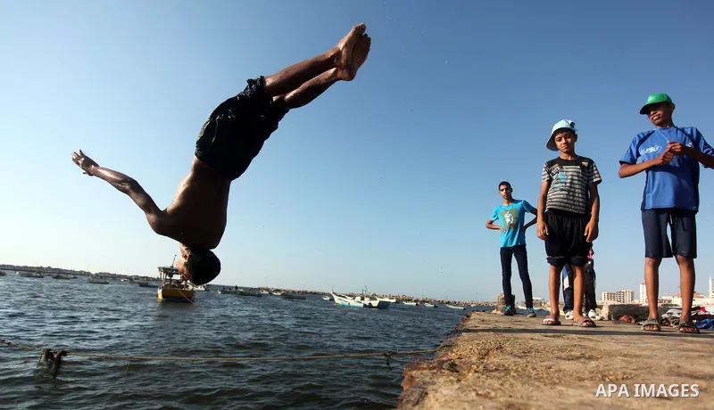A Palestinian boy jumps into the water at the port in Gaza City during a protest against the Israeli blocking of a boat of foreign activists from reaching Gaza, June 29, 2015. Israel said on Monday it had blocked a boat...