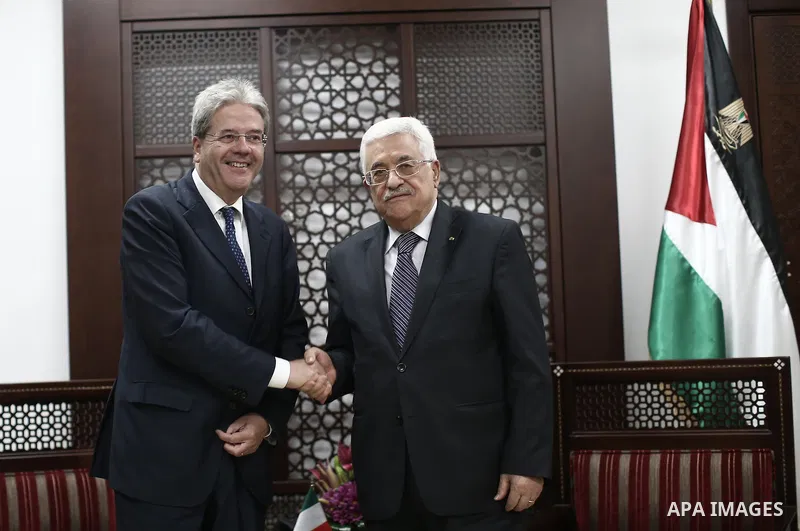 Palestinian President Mahmoud Abbas (R) shakes hands wirh Italian Foreign Minister Paolo Gentiloni in the West Bank city of Ramallah June 29, 2015. apaimages/Fadi Arouri/Pool