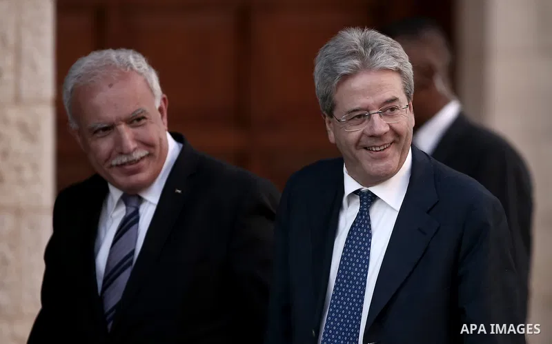 Palestinian Foreign Minister Riyad Al-Malki (L) walks with his Italian counterpart Paolo Gentiloni in the West Bank city of Ramallah on June 29, 2015. apaimages/Fadi Arouri/Pool