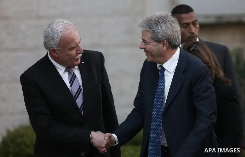 Palestinian Foreign Minister Riyad Al-Malki (L) shakes hands with his Italian counterpart Paolo Gentiloni in the West Bank city of Ramallah on June 29, 2015. apaimages/Fadi Arouri/Pool