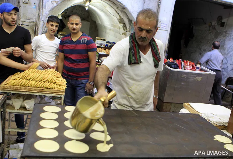 A Palestinian man prepares traditional pancakes known as ''Qatayef'' on the holy month of Ramadan, in Jerusalem's old city on June 29, 2015. During Ramadan, Muslim believers abstain from eating, drinking, smoking and hav...