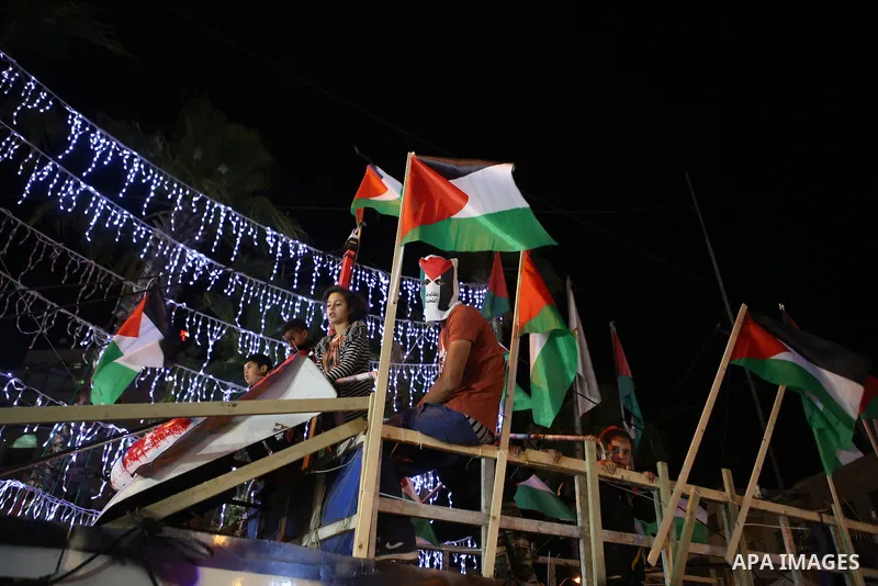 Palestinian activists sit on a model of a ship during a rally in solidarity with activists aboard a flotilla of boats who are soon to set sail for Gaza in a fresh bid to break Israel's blockade of the territory, in the W...