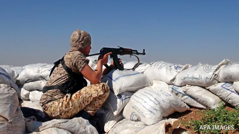 A fighter from the Free Syrian Army's Al-Tawhid Brigade takes a position at the border with Dabiq city, the stronghold of the ISIS fighters, in the Mare' city in the north of Aleppo, on June 30, 2015. Photo by Ameer al-H...