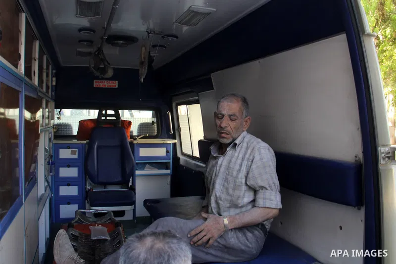 A Syrian man awaits treatment at an ambulance after a reported bomb barrel attack by Syrian government forces in Aghyar district in the northern Syrian city of Aleppo July 1, 2015. Photo by Ameer al-Halbi