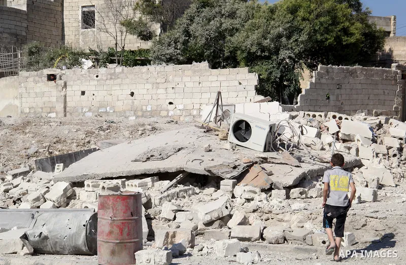 A Syrian boy walks in an a street after a reported bomb barrel attack by Syrian government forces in Bab al-Nairab district in the northern Syrian city of Aleppo, on July 1, 2015. Photo by Ameer al-Halbi