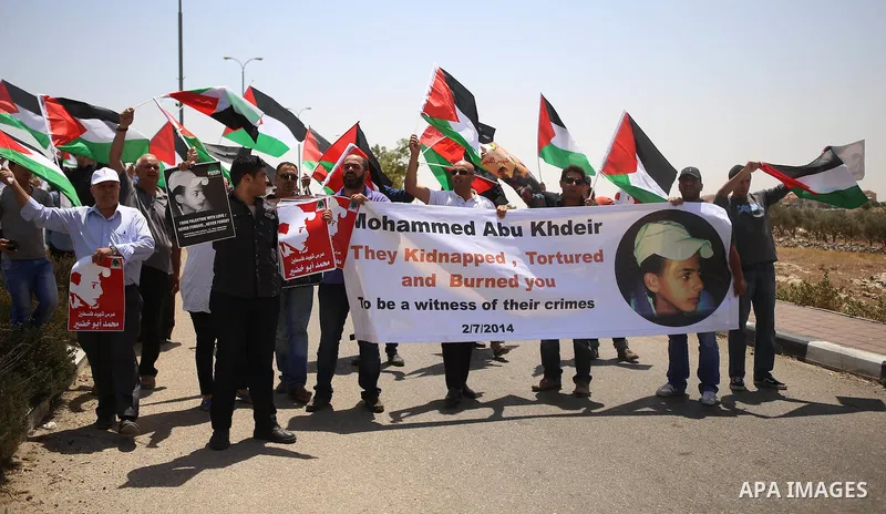 Palestinian protesters block a road leading to the Adam settlement, located near the West Bank village of Jabba, during a demonstration to mark the first anniversary of the killing of 16-year-old Palestinian Mohammed Abu...