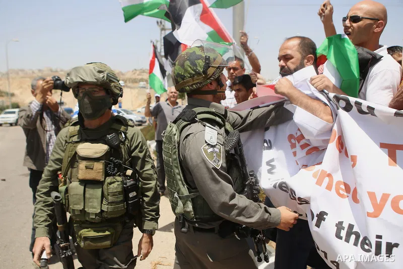 Journalists scuffle with a member of the Israeli security forces on July 2, 2015, as they cover a demonstration by Palestinians on a road leading to the Adam settlement, located near the West Bank village of Jabba, to ma...