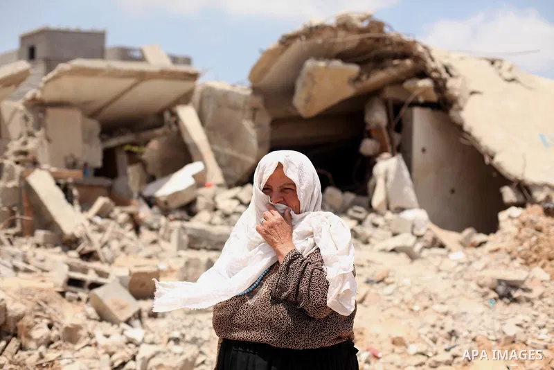 A Palestinian woman looks on as she stands in front of the ruins of her house, that witnesses said was destroyed by Israeli shelling during a 50-day war last summer, in Khan Younis in the southern Gaza Strip July 2, 2015...