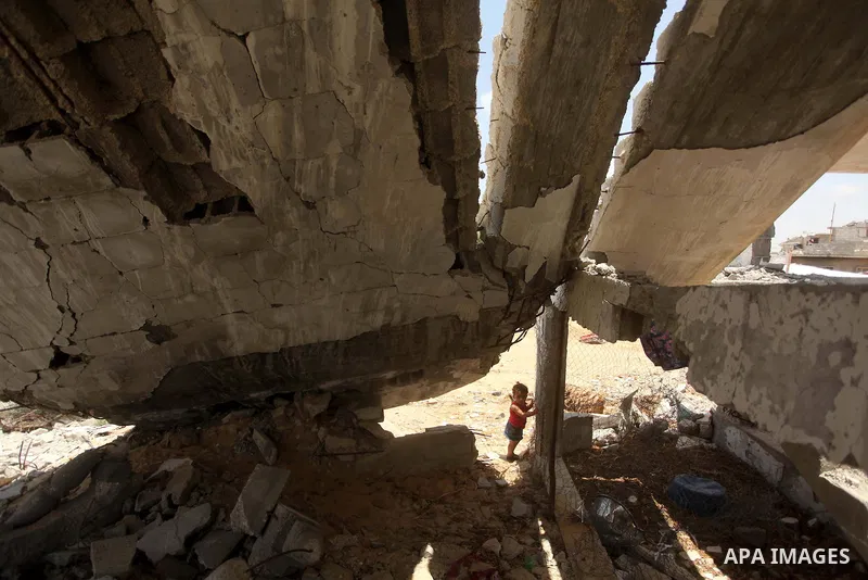 Palestinian childern play on the ruins of houses, that witnesses said were destroyed by Israeli shelling during a 50-day war last summer, in Khan Younis in the southern Gaza Strip July 2, 2015. Robert Turner has no quick...