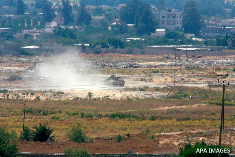 A picture taken from the Rafah border of the southern Gaza Strip with Egypt shows an Egyptian armored vehicle patroling the area on the Egyptian side of the border on July 2, 2015. At least 70 people, mostly Egyptian sol...