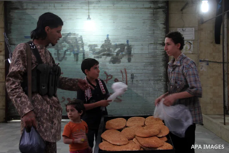 A Syrian street vendor sells breads at a popular marketplace in the northern Syrian city of Aleppo, on July 4, 2015. During Ramadan, Muslim believers abstain from eating, drinking, smoking and having sex from dawn until...