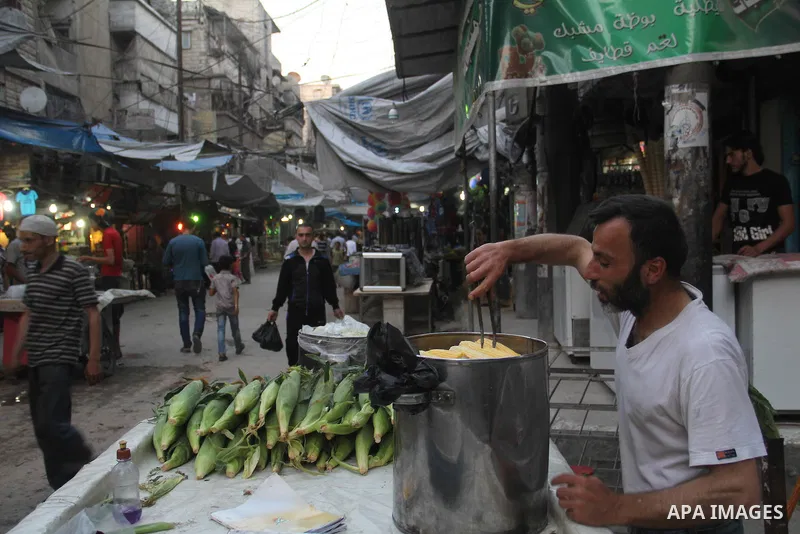 A Syrian street vendor sells corns at a popular marketplace in the northern Syrian city of Aleppo, on July 4, 2015. During Ramadan, Muslim believers abstain from eating, drinking, smoking and having sex from dawn until s...