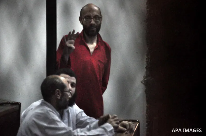 Egyptian Muslim Brotherhood defendants stand behind the bars during their trial, along with ousted Islamist president Mohamed Morsi (unseen), in Cairo on July 04, 2015. Photo by Amr Sayed