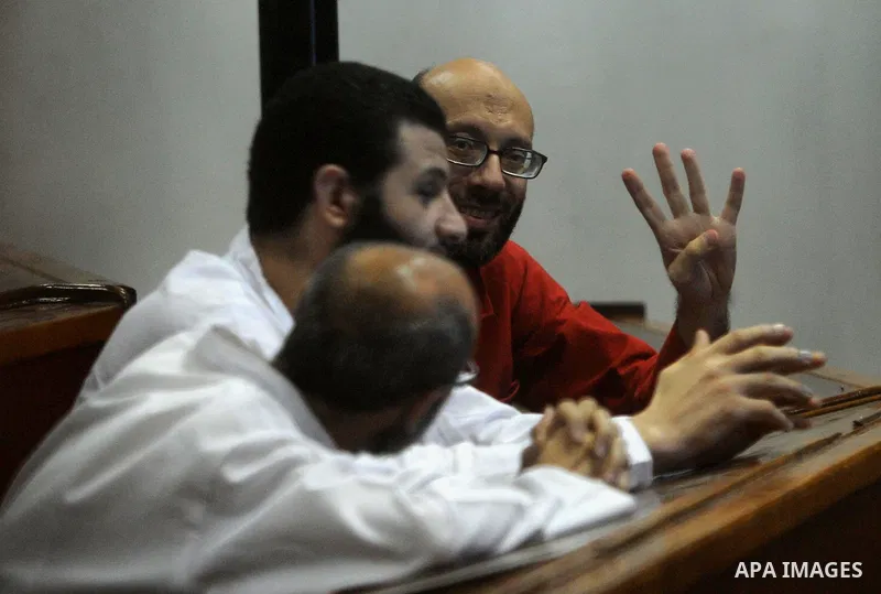 Egyptian Muslim Brotherhood defendants stand behind the bars during their trial, along with ousted Islamist president Mohamed Morsi (unseen), in Cairo on July 04, 2015. Photo by Amr Sayed