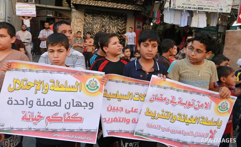 Palestinian supporters of Hamas movement hold placards during a protest against the political arrest campaign by the PA forces in the West Bank, in Jabalia refugee camp in the northern Gaza Strip, July 7, 2015. Palestini...